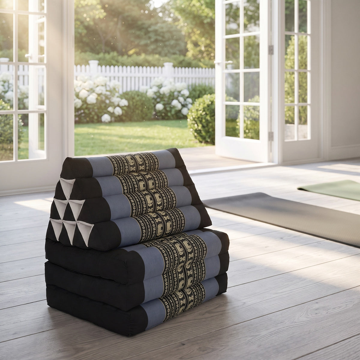Blue elephant pattern Thai triangle floor mattress daybed, folded, in a garden yoga studio