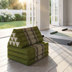 Green Thai triangle floor mattress daybed, folded, in a garden yoga studio