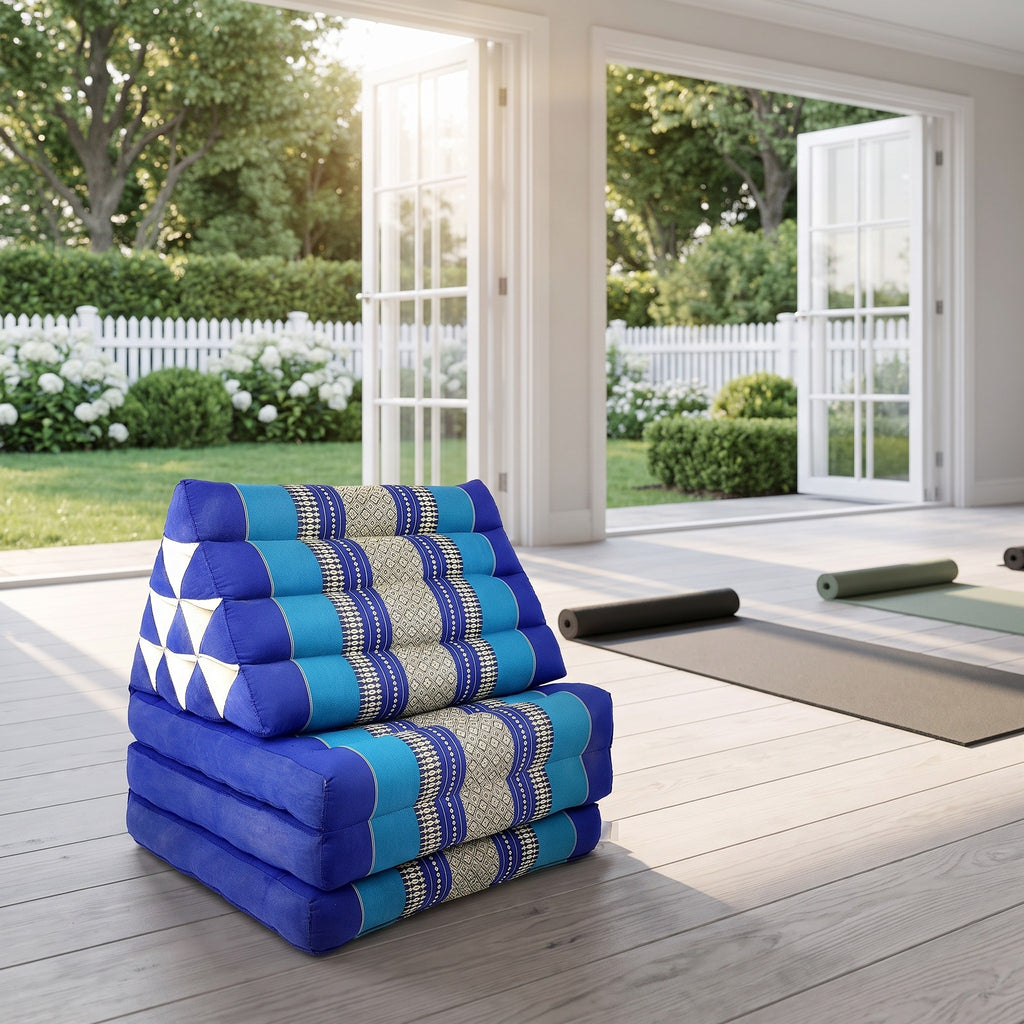 Navy Thai triangle floor mattress daybed, folded, in a garden yoga studio