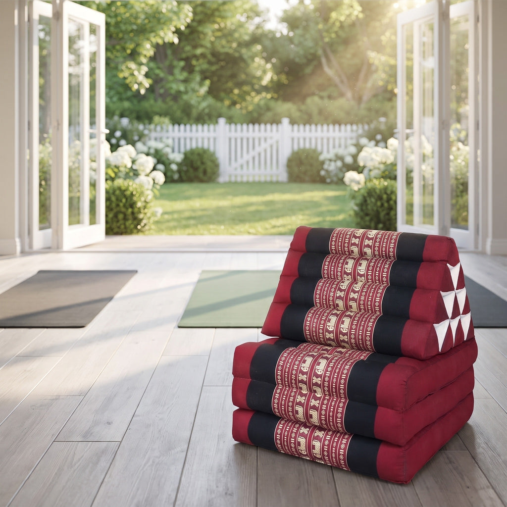 Red elephant pattern Thai triangle floor mattress daybed, folded, in a garden yoga studio