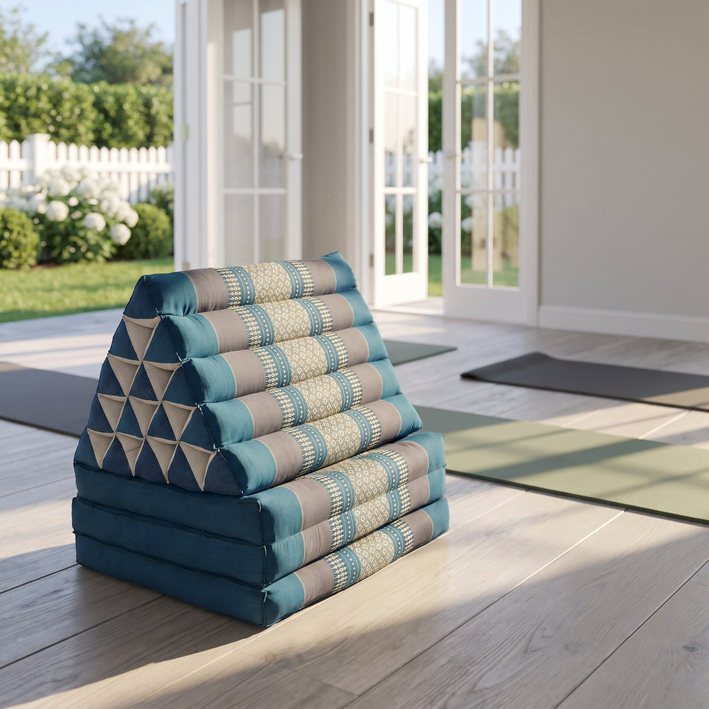 Blue Jumbo 3-fold Thai triangle floor mattress, folded, in a garden yoga studio