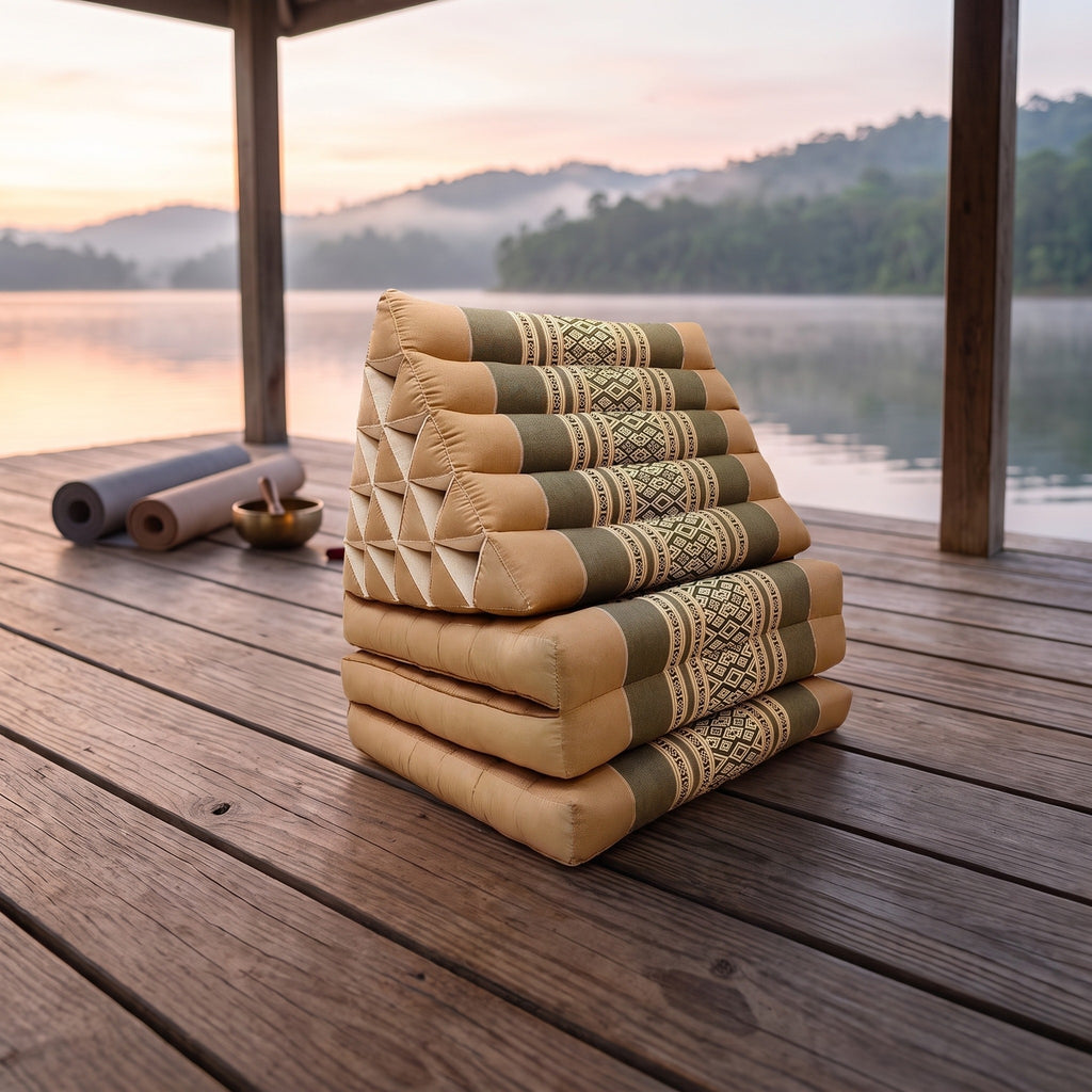 Cream Jumbo 3-fold Thai triangle floor mattress, folded, on a lakeside pavilion at dawn