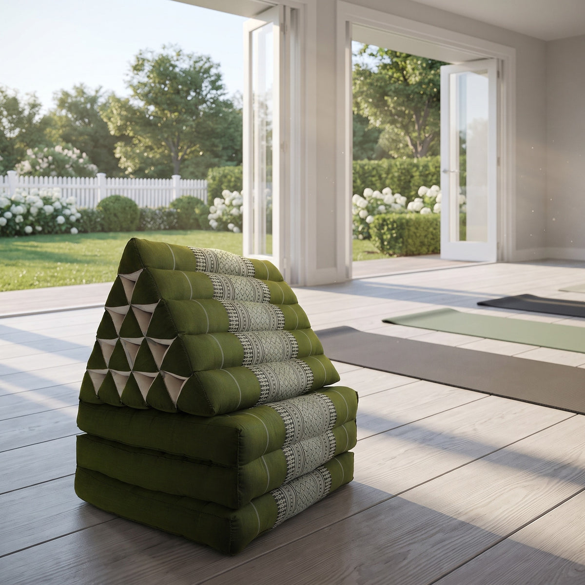 Green Jumbo 3-fold Thai triangle floor mattress, folded, in a garden yoga studio