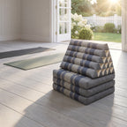 Grey-blue Jumbo 3-fold Thai triangle floor mattress, folded, in a garden yoga studio