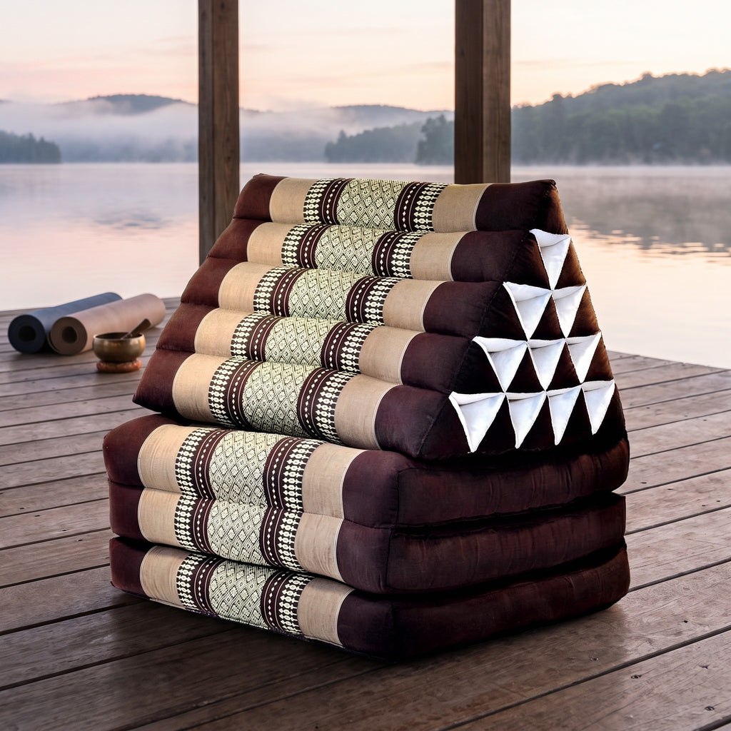 Brown Jumbo 3-fold Thai triangle floor mattress, folded, on a lakeside pavilion at dawn