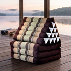 Brown Jumbo 3-fold Thai triangle floor mattress, folded, on a lakeside pavilion at dawn