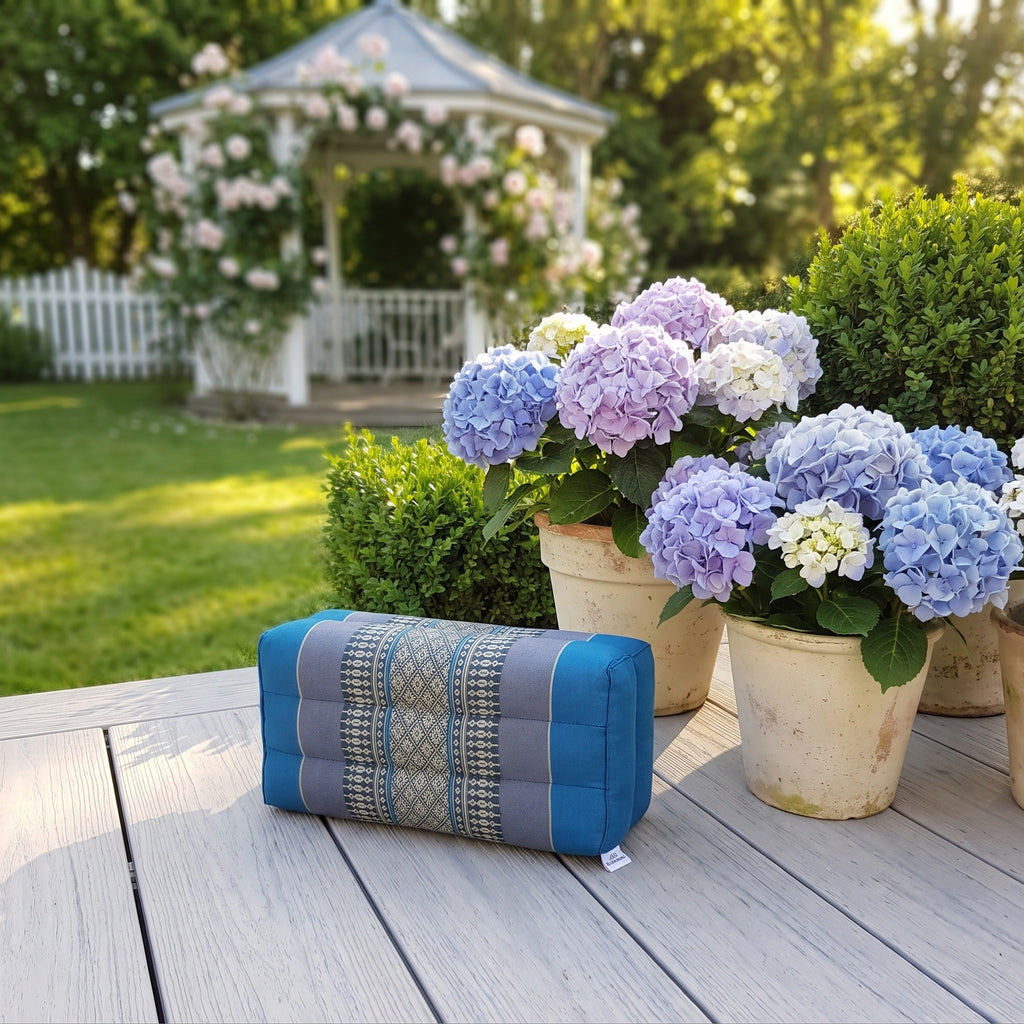 Blue yoga block beside hydrangeas on a garden deck