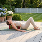 Woman in a supported backbend over a red and green Thai kapok yoga block on a garden deck